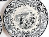 three black and white plates with pictures of people on them on a table