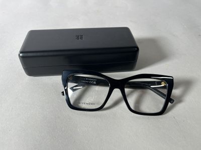 glasses in a black case on a white surface with a black box