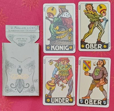 quatre cartes à jouer différentes posées sur une nappe rose