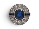 gros plan d'une bague avec une pierre bleue entourée de diamants blancs