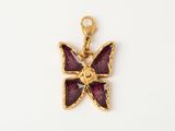 un gros plan d'un pendentif en forme de papillon sur une surface blanche