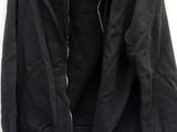 black jacket hanging on a hanger on a white wall next to a pair of shoes