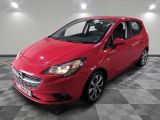 une voiture rouge garée dans un garage au sol en damier