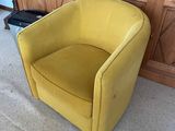 yellow chair in front of a wooden entertainment center in a living room