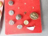 a red box with a bunch of buttons and a pair of scissors