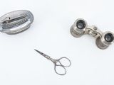 a pair of scissors and a pair of eyeglasses on a white surface