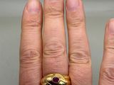 a man ' s hand with a gold ring on it