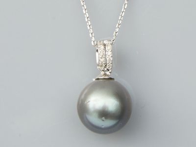 a black pearl and diamond pendant on a silver chain