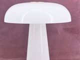 a close up of a white table lamp on a pink surface