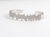 the bracelet is made out of silver metal and has a cross design