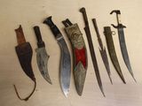 Plusieurs types de couteaux sont exposés sur une table