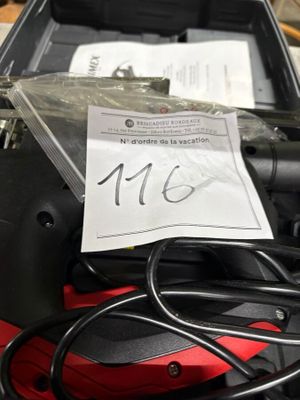 une valise rouge avec une poignée noire posée sur une table