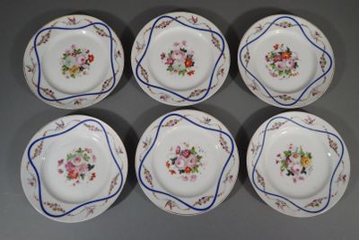 six assiettes ornées de motifs floraux sont disposées sur un fond gris
