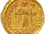 a close up of a gold coin on a white surface