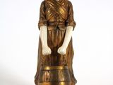 une statue représentant une femme tenant un tonneau de vin