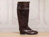 the tall brown boots are sitting on the wooden floor