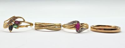 trois bagues en or ornées de pierres de différentes couleurs, posées sur un fond blanc