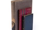 trois livres sont empilés sur une surface blanche
