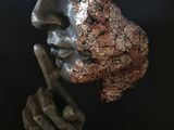 bronze sculpture of a man ' s face on a black base