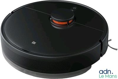 le robot est branché à un chargeur posé sur une surface blanche