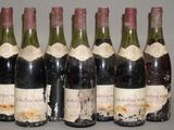 six bouteilles de vin sont alignées sur une table