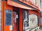 un bâtiment orange sur lequel est affichée une photo en noir et blanc