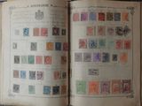 an open book with stamps on it sitting on a table