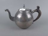 an antique silver teapot on a grey background with a tag on it