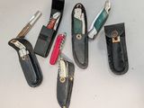 Plusieurs types de couteaux de poche sont disposés sur une table