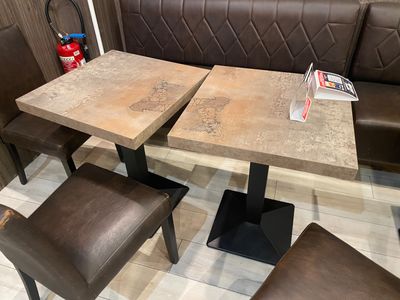a table with two chairs and a bench in the corner