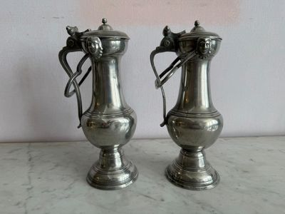 deux vases en argent posés sur un plan de travail en marbre