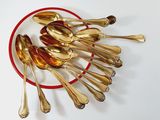 a red plate with silver spoons and spoons on it