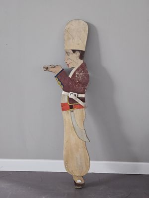 une sculpture en bois représentant un homme tenant un couteau
