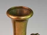 a bronze vase with a frog on it on a table
