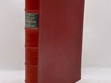 a red book with a green cover sitting on top of a white surface