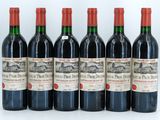 six bottles of red wine lined up on a white surface
