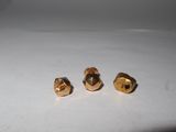 two gold studs sitting on top of a white surface