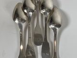 six silver spoons are arranged in a row on a white surface