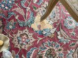 a cat that is sitting on a rug on the floor