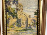 une peinture à l'huile représentant une église, dans un cadre en bois, posée sur une table