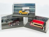 trois voitures miniatures dans une vitrine posée sur une table