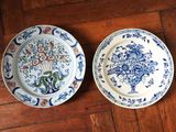 deux assiettes ornées de motifs bleus et blancs, posées sur un plancher en bois