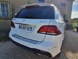 the rear end of a white car parked in front of a house