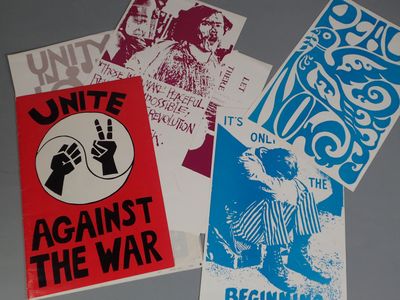 quatre affiches posées sur une table, dont l'une à caractère politique