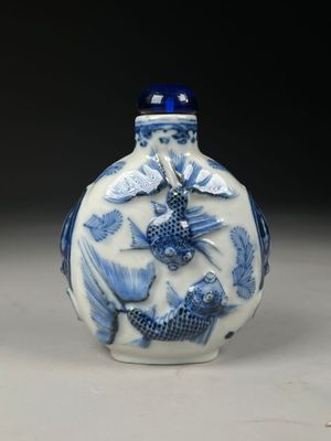 un vase bleu et blanc orné d'un motif de poisson