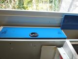 a blue phone sitting on top of a shelf next to a window