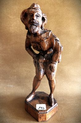 wooden figurine of a man holding a baseball bat on a wooden base