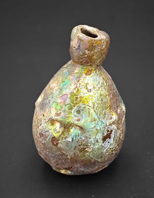 un petit vase posé sur une surface noire