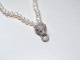 necklace with white pearls and a silver elephant head on a white background
