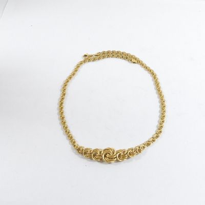 un bracelet en chaîne dorée orné d'un motif de nœud sur fond blanc